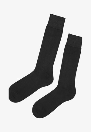 Sorte knælange strømper lavet af et glat, strækbart materiale med en ribbet manchet og sømløs konstruktion for en behagelig pasform.