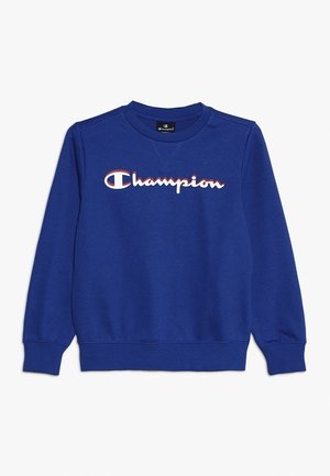 Niebieska bluza Champion z długim rękawem, ściągaczami, okrągłym dekoltem i logo Champion w białym i czerwonym kolorze na piersi.