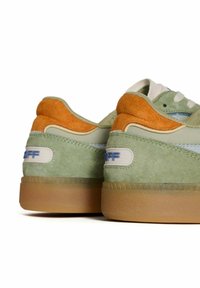 Las zapatillas de ante verdes y naranjas presentan una suela de goma, acentos de color azul claro y sobrecapas texturizadas en el talón y en la parte superior para un detalle adicional.