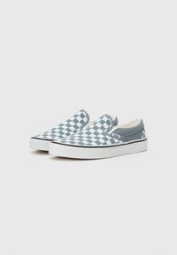 Zapatos slip-on en un patrón a cuadros azul y blanco, con un acento sólido azul en el talón y una suela de goma blanca.