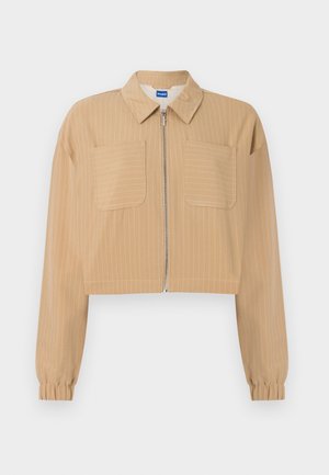 Μπεζ cropped σακάκι με λεπτές λευκές ρίγες, φερμουάρ μπροστά, δύο τσέπες στο στήθος, μακριά μανίκια με ελαστικά μανσέτα και μυτερό γιακά.