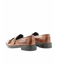 Scarpe slip-on in pelle marrone con una finitura liscia, punta rotonda e suola in gomma nera; presentano fibbie argentate sul davanti.