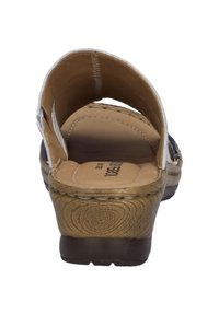 Brown and gold sandal with an open back and closed toe. The upper features a textured design. Contoured sole for comfort.