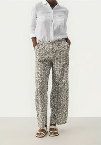 Witte linnen overhemd met knopen, gecombineerd met geprinte, wijde broek in crèmekleurige en bruine tinten, met een elastische tailleband en zijzakken.