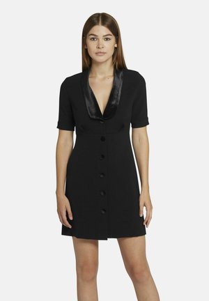 Zwarte jurk met een satijnen sjaalkraag, korte mouwen en een knoopsluiting aan de voorkant. Glad materiaal met een getailleerde silhoutte en een lengte tot de knie.