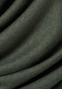 Ciemnozielony materiał o miękkiej, gładkiej fakturze, z delikatnym wzorem dzianiny i zwisającymi fałdami, wskazującymi na elastyczność i ciepło.