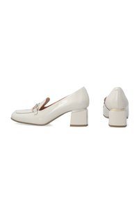 Witte gepatenteerde leren loafers met blokhak hebben een ronde neus en een decoratieve band met een gesp. Gladde afwerking, hak van gemiddelde hoogte.