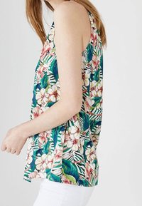 Bloemen tanktop met een groen, roze en witte print van tropische bloemen en bladeren; gemaakt van lichtgewicht stof; mouwloos ontwerp.