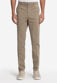 Chino da uomo color khaki in cotone con design a gamba dritta, tasche anteriori e zip, abbinati a sneakers in suede grigie.