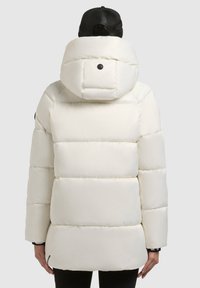 Fehér puffertakaró kapucnival, steppelt részekkel, nagy gallérral és hátul gombos részlettel. Simább, fényes textúrájú anyag.