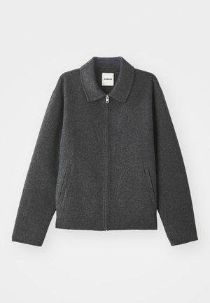 Grau melierte Wolle-Jacke mit Kragen, Frontreißverschluss und zwei Seitentaschen. Hat eine lockere Passform mit leicht schmaler werdenden Ärmeln.