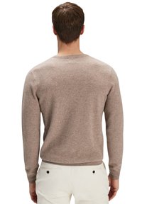 Ljusbrun stickad tröja med långa ärmar, rund halsringning och en mjuk textur. Har ribbade ärmslut och nederkant.