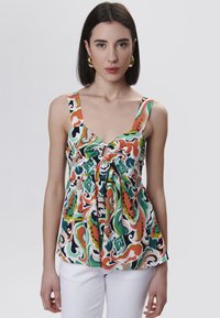 Kleurvolle mouwloze top met een diepe V-hals, knoopdetail in het midden en een levendig, draaiend bloemenpatroon in groen, oranje en zwart.