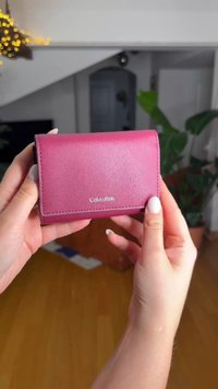 Πορτοφόλι Calvin Klein σε ροζ φούξια δέρμα με απαλό υφή, ορθογώνιο σχήμα και ασημένιο λογότυπο στο μπροστινό μέρος.