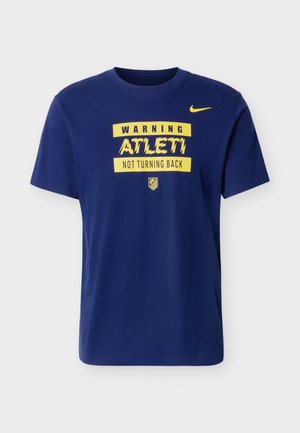 Marineblaues Nike-T-Shirt mit gelbem Text "WARNING ATLETI NOT TURNING BACK" und einem kleinen Atletico Madrid-Logo unter dem Text.