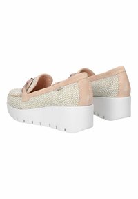 Scarpe con zeppa caratterizzate da una tomaia in tessuto intrecciato color crema con dettagli in suede rosa chiaro. Presentano una suola spessa bianca e un elegante dettaglio a fiocco.