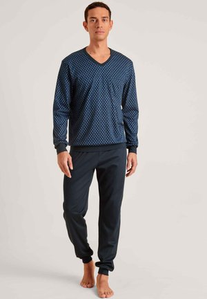 Haut à manches longues bleu marine en V avec des pois bleu clair, associé à un pantalon sombre avec des poignets élastiques pour un ajustement confortable.
