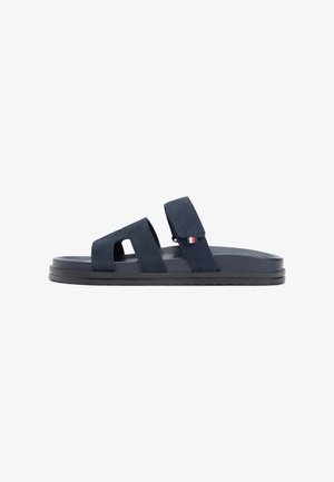 Sandales bleu marine avec deux sangles velcro ajustables, semelle plate, et finition texturée. Présentent un petit logo de la marque en rouge, blanc et bleu.