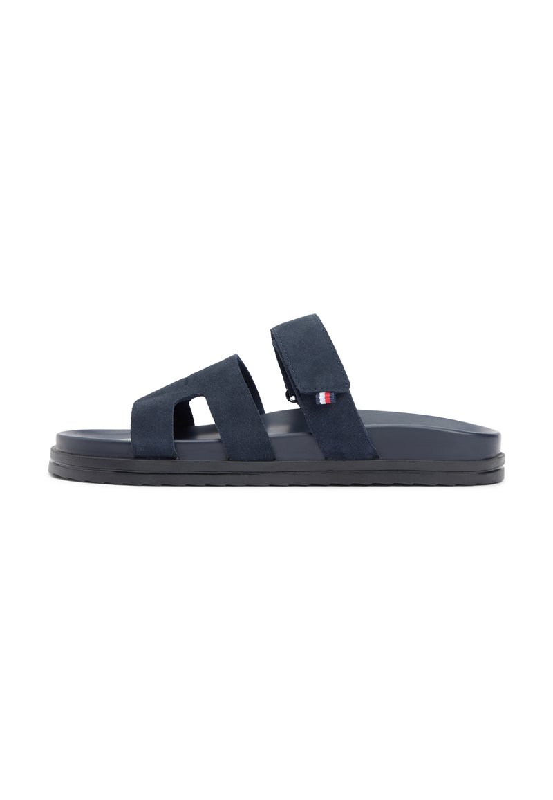 Σανδάλια ναυτικού μπλε με δύο ρυθμιζόμενους ιμάντες βέλκρο, επίπεδη σόλα και υφή με ανάγλυφο φινίρισμα. Διαθέτουν μικρό λογότυπο της μάρκας σε κόκκινο, άσπρο και μπλε.