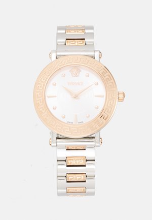 Reloj Versace con dial redondo blanco, bisel en tono dorado con patrón de llave griega y correa bicolor de acero inoxidable en plata y oro rosa.