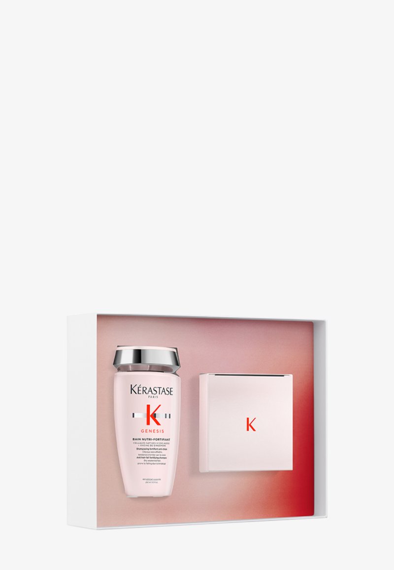 Bouteille de shampooing Kérastase Genesis et boîte assortie rose avec un bouchon argenté, présentées dans un emballage cadeau dégradé blanc et rose.