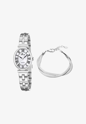 Reloj de pulsera plateado con esfera ovalada blanca y números romanos junto a una pulsera de cadena plateada de múltiples hilos con cierre de langosta.