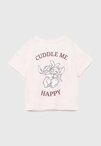 Krátký rukáv, světle růžové tričko s ilustracemi kreslených postaviček objímajících se, s textem "CUDDLE ME HAPPY" v burgundské barvě nad a pod ilustrací.