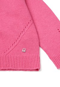 Różowy sweter z dzianiny z prążkowanym wykończeniem u dołu i na mankietach, z subtelnymi wzorami i małym srebrnym emblematem z przodu.