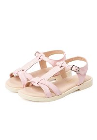 Sandali in pelle rosa con design a T, fibbia argentata regolabile e suola piatta bianca. Dettagli testurizzati nella parte superiore e stile aperto sul retro.