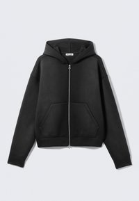 Sweat à capuche noir zippé en tissu doux, avec une poche avant, une capuche et des poignets côtelés. Design minimaliste sans motifs visibles.