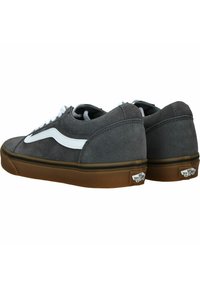 Zapatillas de ante gris con una franja lateral blanca, punta redonda y suela de goma marrón. Presentan cordones blancos en contraste y un logotipo en el talón.