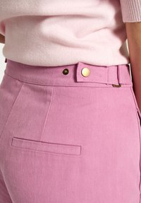 Rosa denim bukser med høj talje, der har en glat tekstur, guldtonede detaljer og en diskret baglomme.