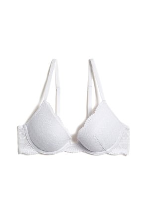 Reggiseno bianco in pizzo con coppe imbottite, spalline regolabili e bordi scallopati. Presenta motivi floreali testurizzati e una chiusura a gancio e molla.
