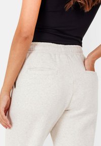 Hellgraue Sweatpants mit elastischem Bund, einer einzigen Gesäßtasche und einem weichen, strukturierten Stoff.