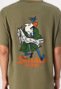 Olivově zelené tričko s karikovým designem muže s mapou a ptákem. Logo "Barbour" v tučné oranžové barvě na spodní části.