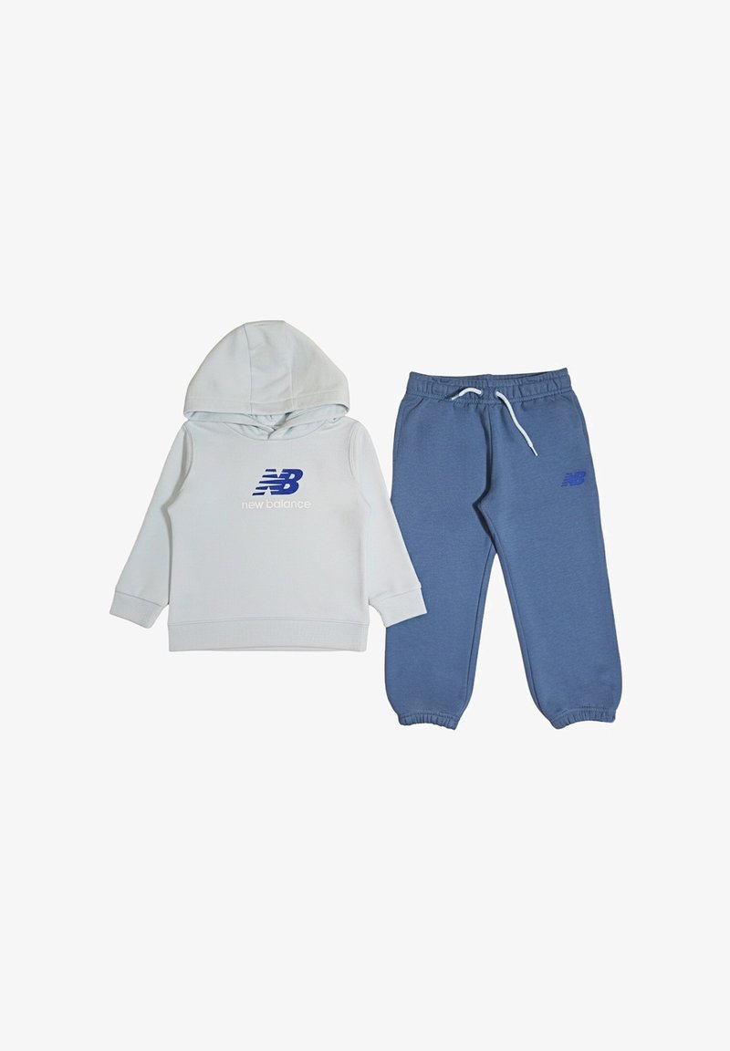Felpa bianca con cappuccio e logo "New Balance" blu, abbinata a pantaloni sportivi blu con cintura elastica e polsi elastici.