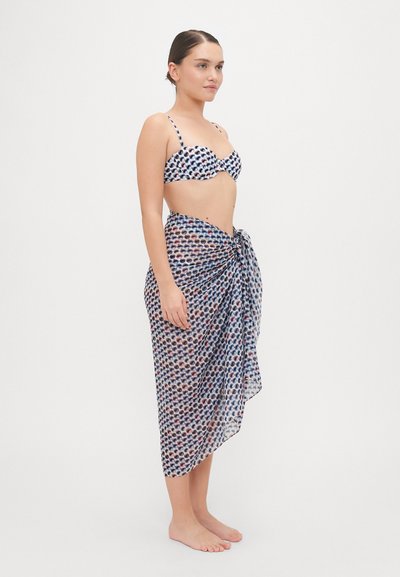 Bikini pehmeast kangast mustriga ülaosaga, millele on lisatud läbipaistev, sidumisse tehtud sarong, millel on korduv muster sinises, valges ja punases.
