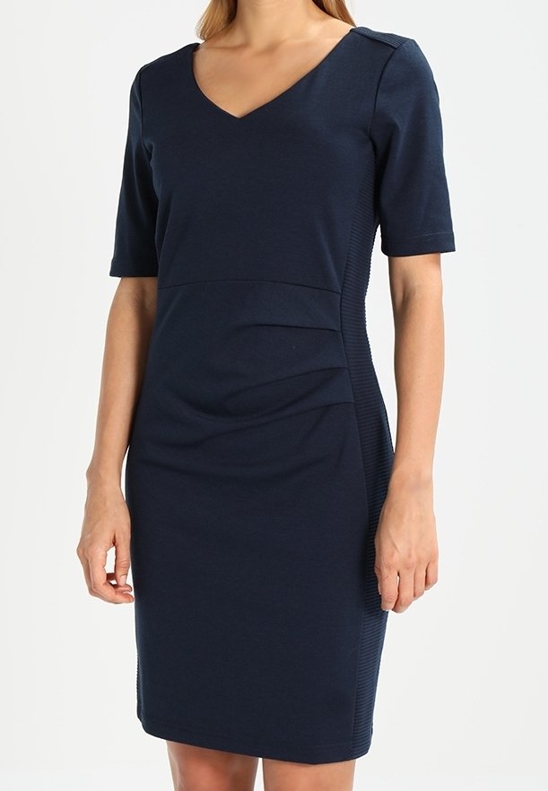 Mörkblå, figurnära klänning med korta ärmar, v-ringning, texturerade sidopaneler och rynkade detaljer i midjan för en skräddarsydd look.
