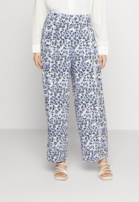 Wide-leg pants made of lightweight fabric featuring a blue and white leopard print. Elastic waistband; smooth texture; paired with strappy white sandals.