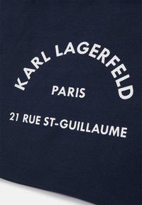 Granatowa torba płócienna z białym napisem: "KARL LAGERFELD", "PARYŻ" oraz "21 RUE ST-GUILLAUME" w zaokrąglonym układzie.