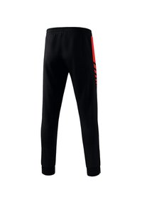 Schwarze Sporthosen aus leichtem Material, mit einem roten Seitenstreifen im gestreiften Design und einem elastischen Bund. Mit Bündchen an den Knöcheln.