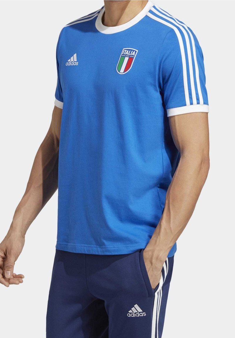 Blå bomullströja med vita detaljer, rund hals, och italiensk flagga logotyp på bröstet. Tre vita ränder på axlarna.