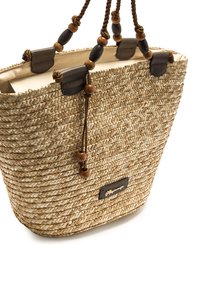 Bolso tote de paja trenzada con detalles en cuero marrón y asas decoradas con cuentas. Diseño de apertura superior, color natural claro y acabado texturizado.