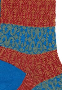 Multicolored socks featuring red and gold patterned sections, with a blue and green geometric design. Textured material with contrasting hues.