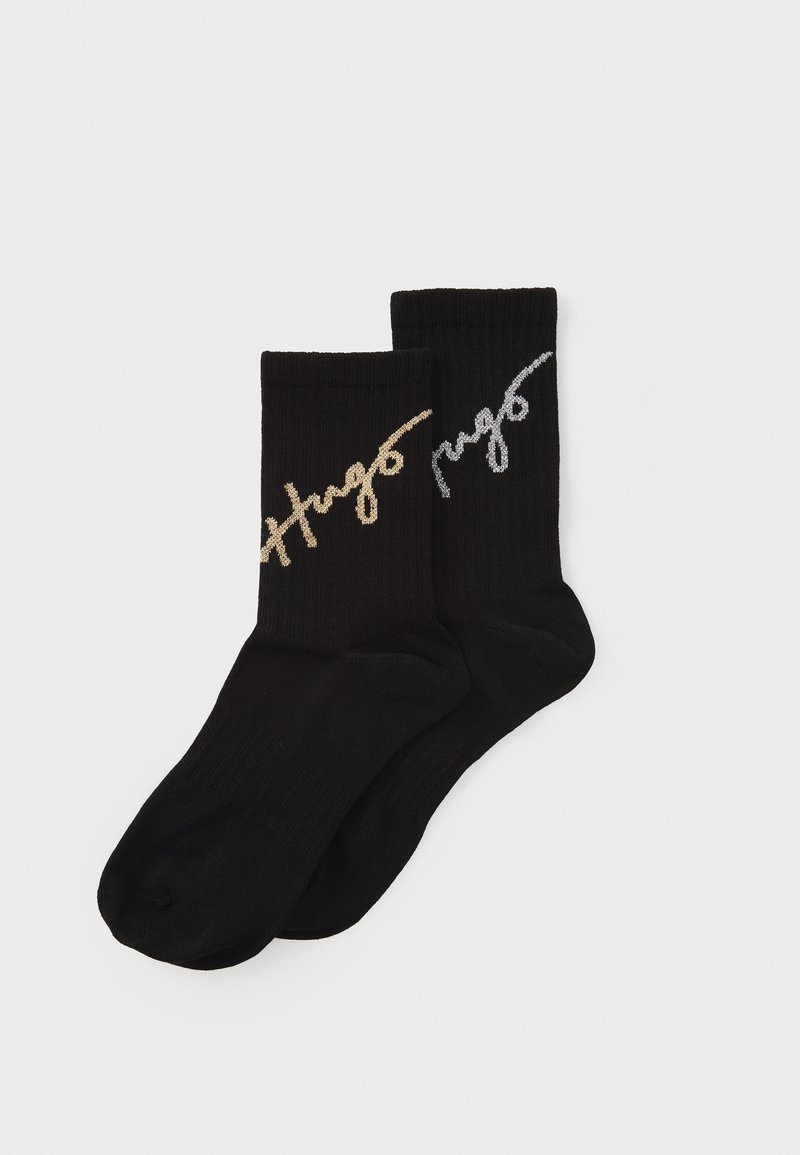 Black ribbed socks featuring the embroidered logo "Hugo" in silver and gold on the outer sides. Soft fabric with a comfortable fit.