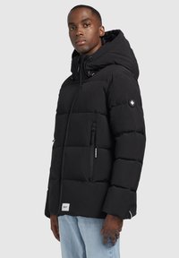 Schwarze Daunenjacke mit Kapuze, ausgestattet mit einem Reißverschluss auf der Vorderseite, seitlichen Taschen und einem Logo-Patch am Ärmel. Glattes Material mit gestepptem Muster.