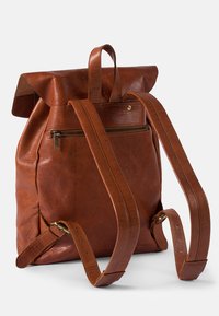 Brown leather backpack with a roll-top design, zippered back pocket, and adjustable straps. Features a smooth texture and minimal hardware accents.