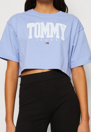 Světle modré oříznuté tričko z bavlny s logem "TOMMY JEANS" v tučném bílém písmu, s krátkými rukávy a volným střihem.