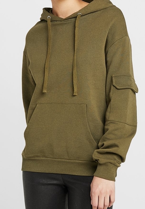 Sudadera con capucha de color verde oliva con bolsillo delantero, cordones ajustables y mangas largas. Cuenta con un bolsillo parche en el brazo izquierdo. Tejido suave.