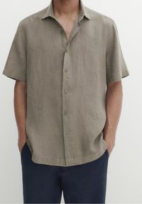 Beige linnen shirt met korte mouwen, een kraag, knopen aan de voorkant en een losse pasvorm, gecombineerd met donkerblauwe broek. Glad in structuur en een minimalistisch ontwerp.